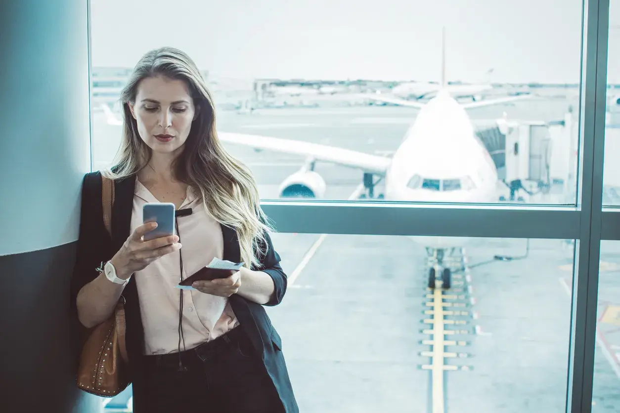 mujer en aeropuerto mirando el móvil
