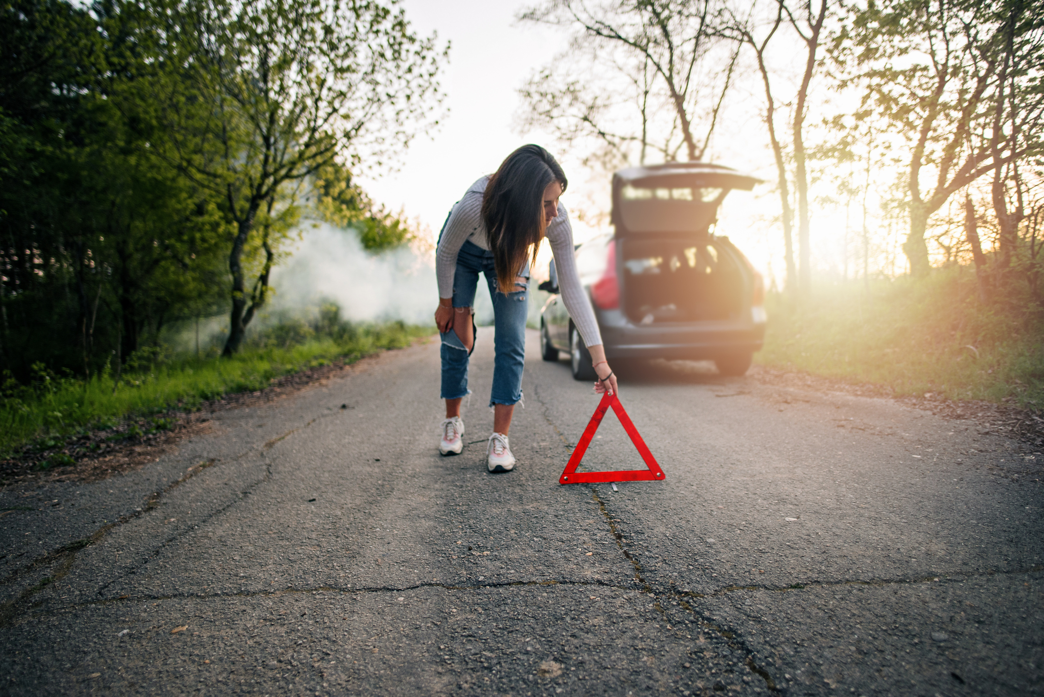 mujer poniendo triángulo en carretera 