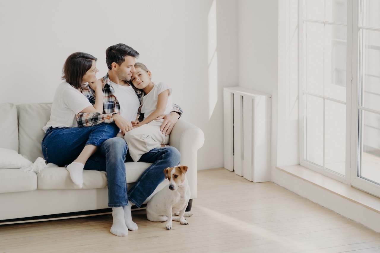 familia sentada en el sofá junto a su perro