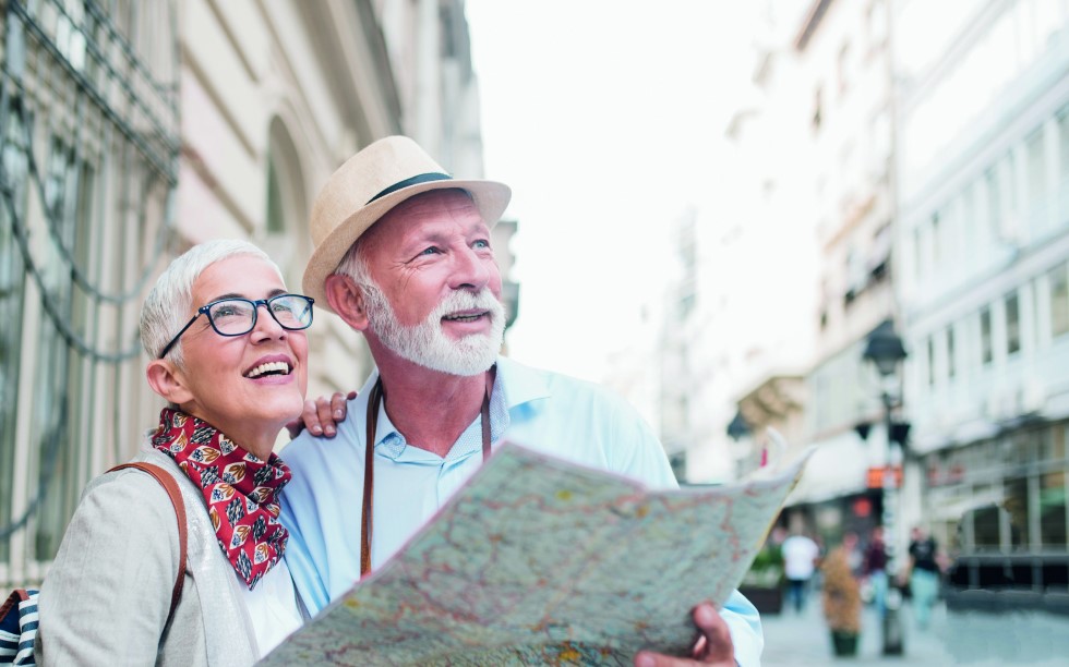 pareja de jubilados mirando un mapa de turismo