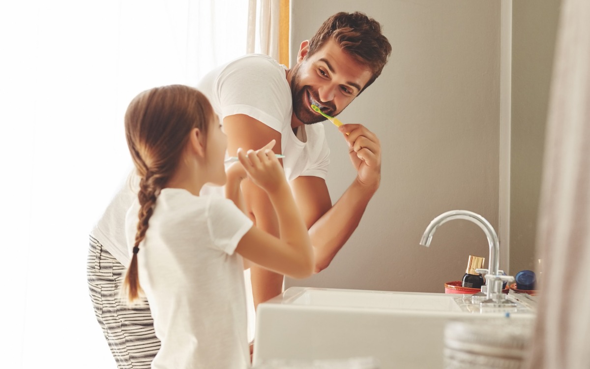 padre e hija en el baño lavándose los dientes