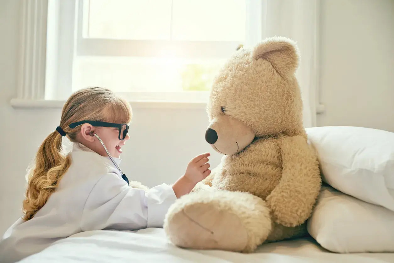 niña cuidando de oso de peluche