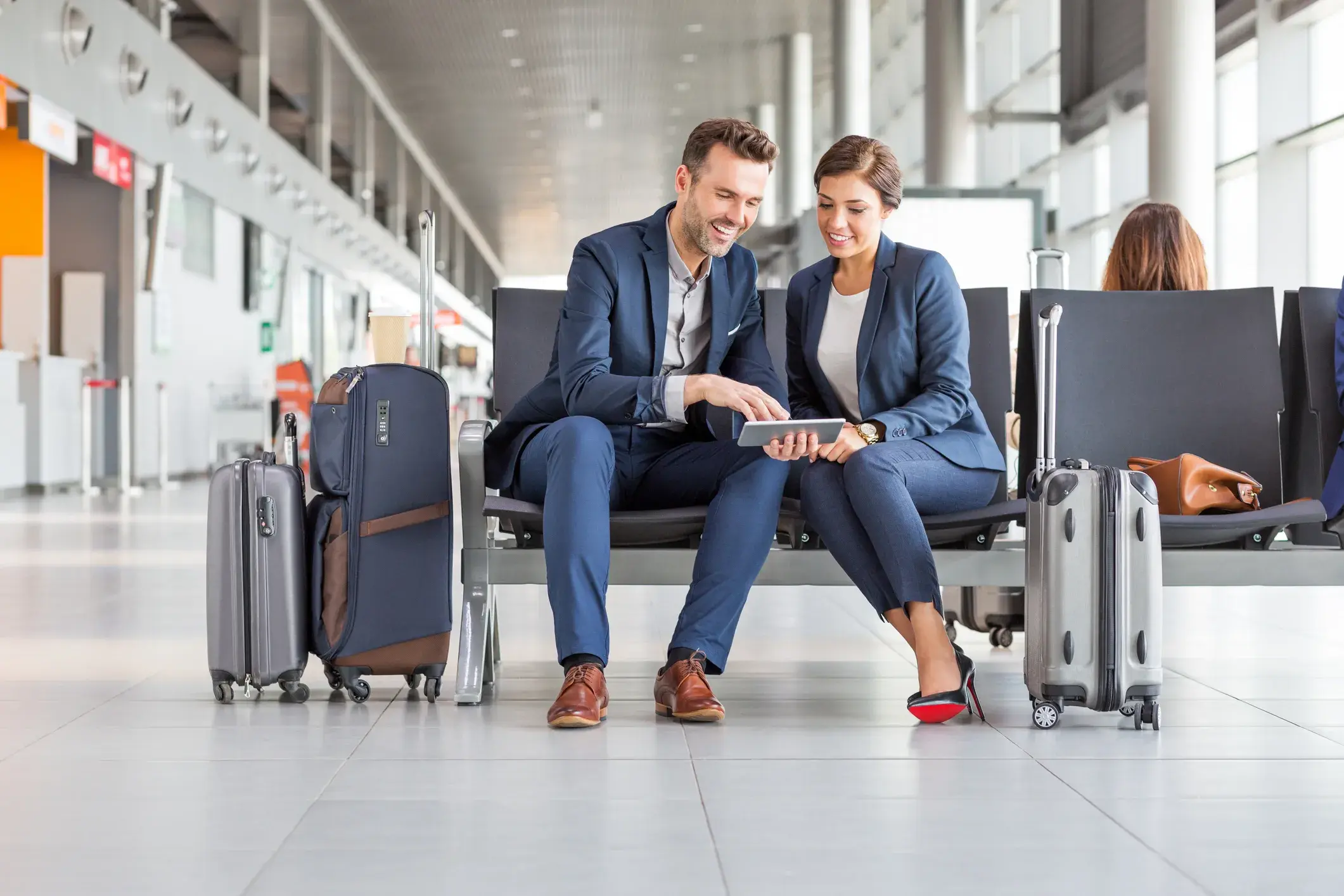 Pareja de negocios esperando el vuelo usando una tableta digital